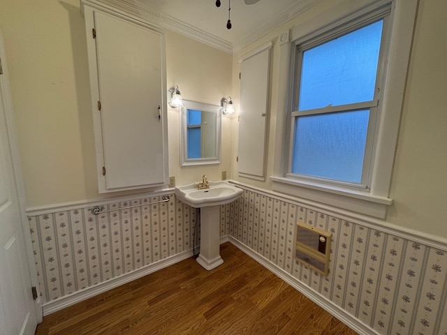 bathroom with hardwood / wood-style floors, heating unit, crown molding, and sink