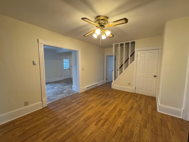 empty room with hardwood / wood-style floors, a baseboard radiator, and ceiling fan