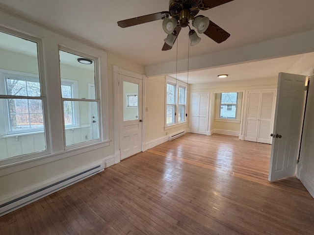 empty room with ceiling fan, hardwood / wood-style floors, and a baseboard heating unit