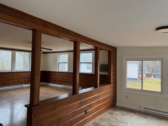 unfurnished room with plenty of natural light, ceiling fan, and a baseboard radiator