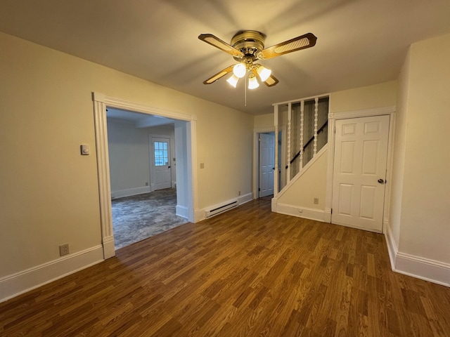 empty room with dark wood-type flooring, ceiling fan, and a baseboard heating unit