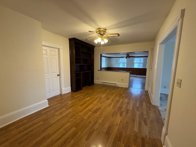 unfurnished living room with baseboard heating, ceiling fan, and dark hardwood / wood-style flooring