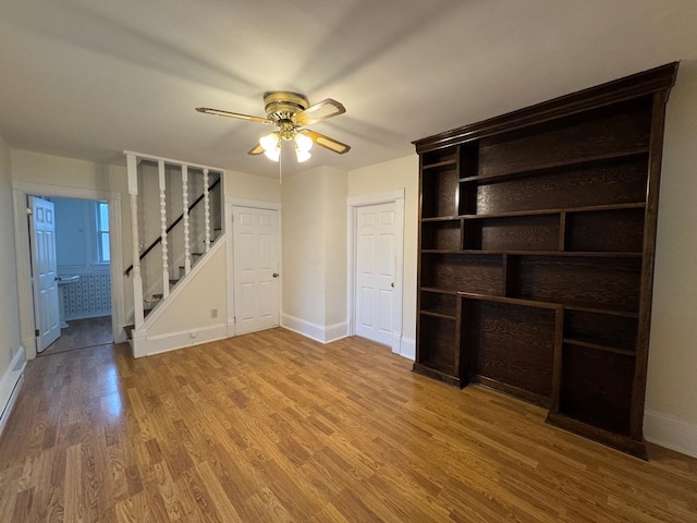 unfurnished living room with hardwood / wood-style flooring and ceiling fan