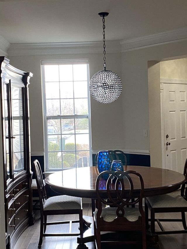 dining space featuring plenty of natural light, a notable chandelier, and ornamental molding