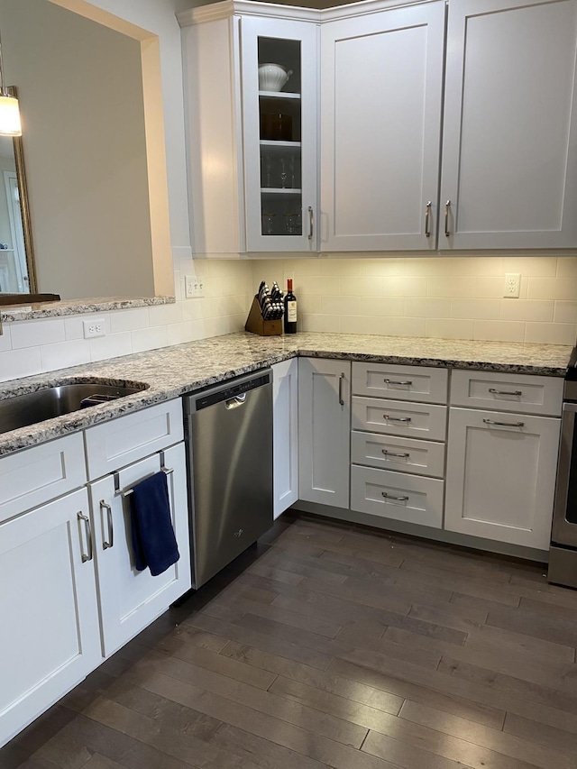 kitchen with stainless steel dishwasher, dark hardwood / wood-style floors, and white cabinets