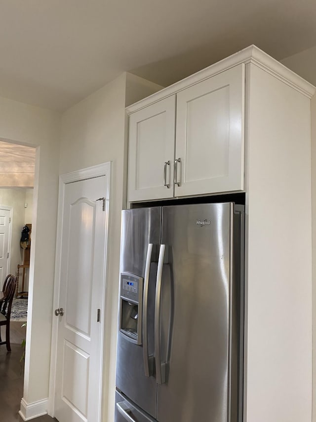 kitchen featuring stainless steel refrigerator with ice dispenser, white cabinetry, and hardwood / wood-style floors