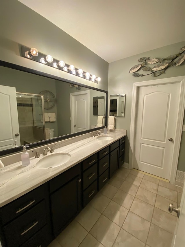 bathroom featuring tile patterned flooring, vanity, and an enclosed shower