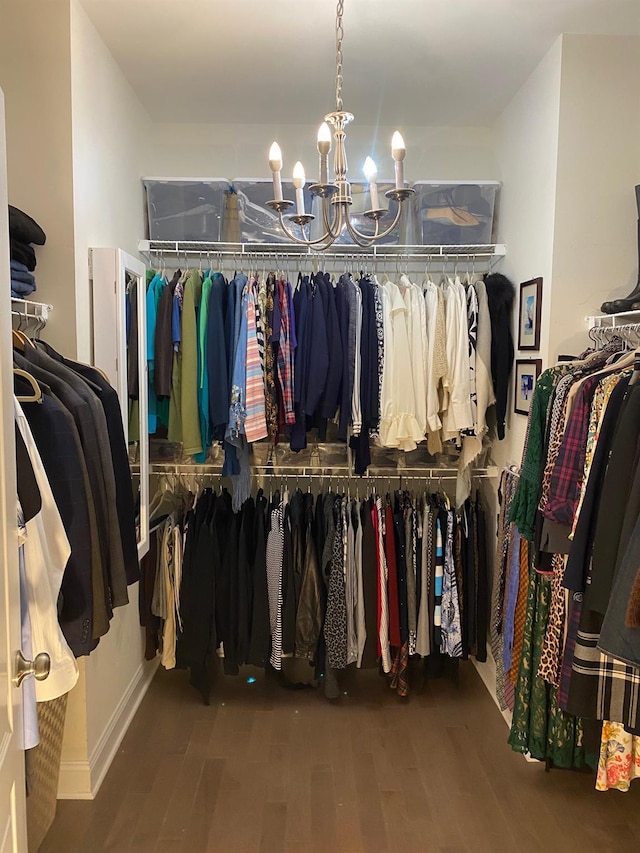 spacious closet with hardwood / wood-style floors and a notable chandelier