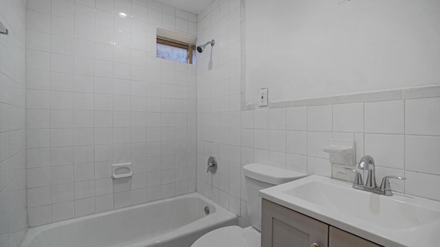 full bathroom with vanity, toilet, tile walls, and tiled shower / bath combo