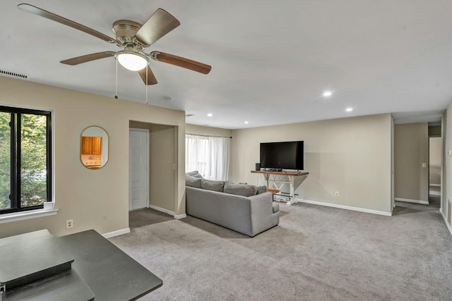 living room featuring light colored carpet, a wealth of natural light, and ceiling fan