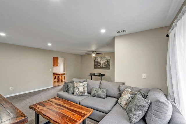 carpeted living room with ceiling fan