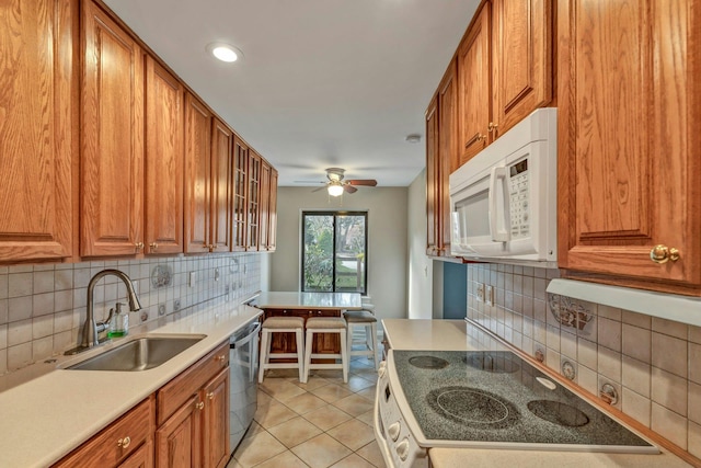 kitchen featuring stove, sink, stainless steel dishwasher, light tile patterned floors, and tasteful backsplash