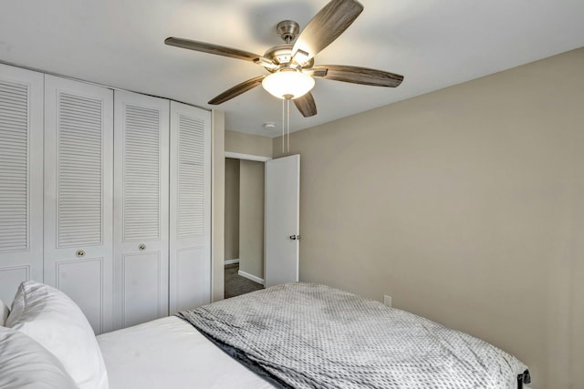 carpeted bedroom with ceiling fan and a closet