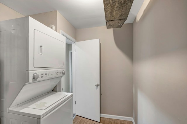 laundry area featuring light hardwood / wood-style flooring and stacked washer / dryer