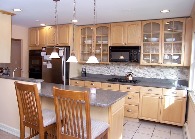 kitchen with a center island, a kitchen breakfast bar, decorative backsplash, light tile patterned flooring, and black appliances