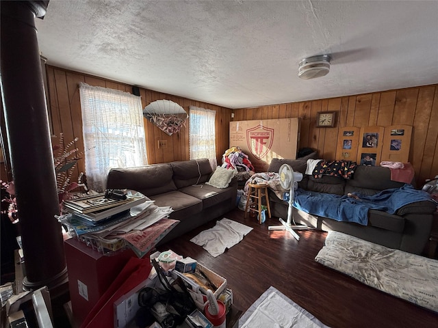 living room featuring a textured ceiling, hardwood / wood-style flooring, and wood walls