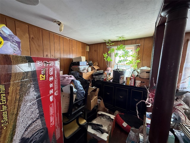 miscellaneous room featuring a textured ceiling and wood walls