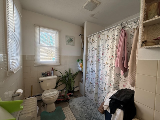 bathroom featuring baseboard heating, shower / bath combo with shower curtain, tile walls, tile patterned flooring, and toilet