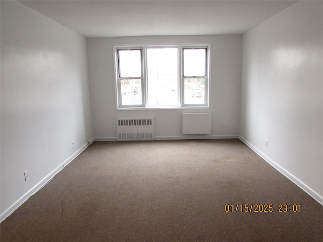 carpeted empty room featuring radiator