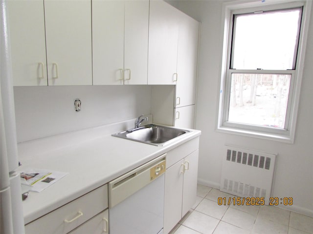 kitchen featuring radiator, light tile patterned floors, dishwasher, and sink