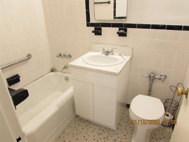 bathroom with toilet, tile walls, tile patterned floors, a washtub, and vanity