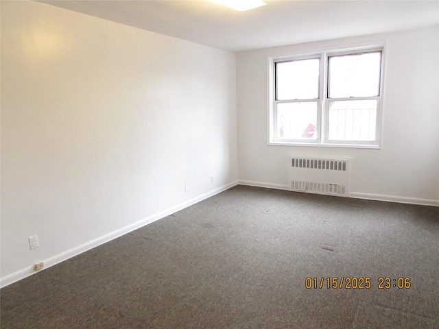 carpeted spare room featuring radiator