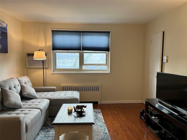 living room featuring dark hardwood / wood-style flooring, an AC wall unit, and radiator