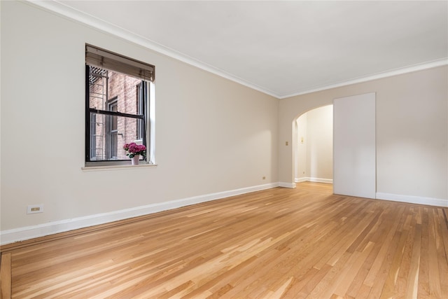 empty room featuring crown molding and wood-type flooring