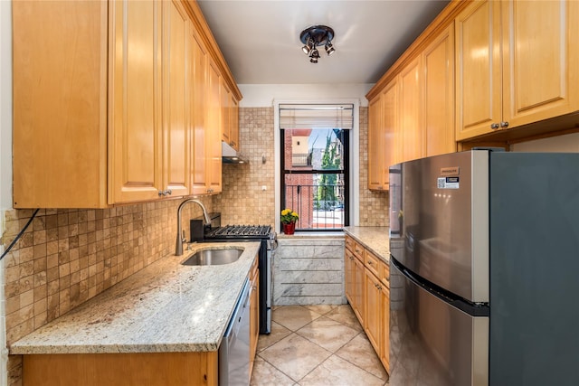 kitchen with light tile patterned flooring, appliances with stainless steel finishes, sink, backsplash, and light stone counters