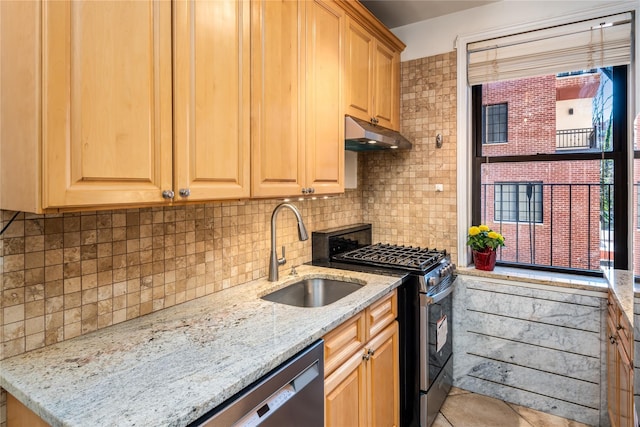 kitchen with appliances with stainless steel finishes, light stone countertops, sink, and backsplash