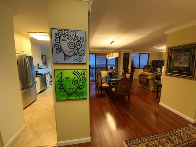 dining space featuring light tile patterned flooring and ornamental molding