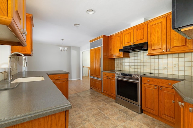 kitchen featuring pendant lighting, stainless steel electric range, sink, decorative backsplash, and a notable chandelier