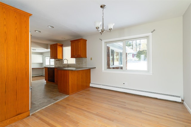 kitchen with baseboard heating, kitchen peninsula, decorative backsplash, and a notable chandelier