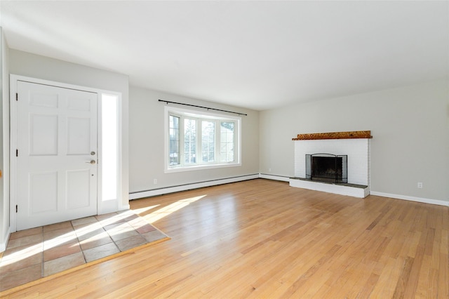 unfurnished living room featuring a fireplace, a baseboard radiator, and light wood-type flooring