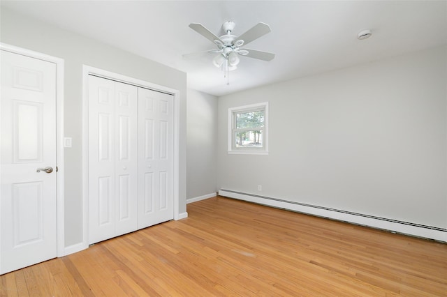 unfurnished bedroom with baseboard heating, ceiling fan, and light wood-type flooring