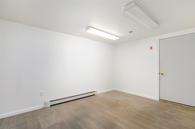 spare room featuring light hardwood / wood-style floors and a baseboard heating unit