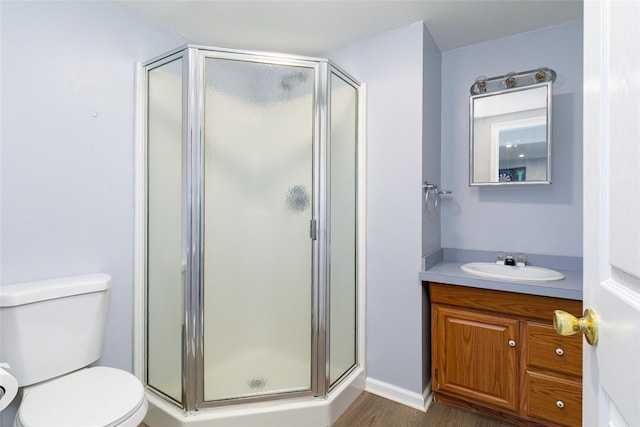 bathroom featuring hardwood / wood-style flooring, toilet, an enclosed shower, and vanity