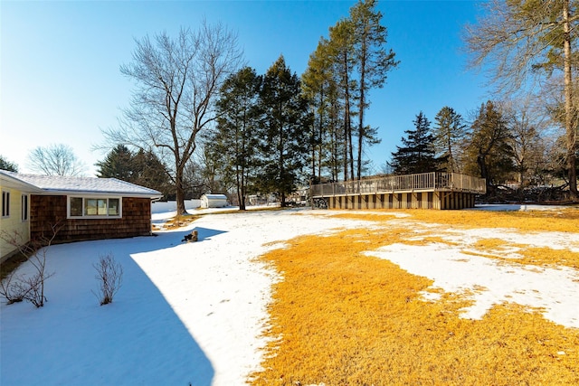 snowy yard featuring a wooden deck