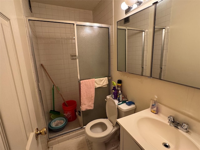 bathroom with vanity, toilet, and a shower with shower door