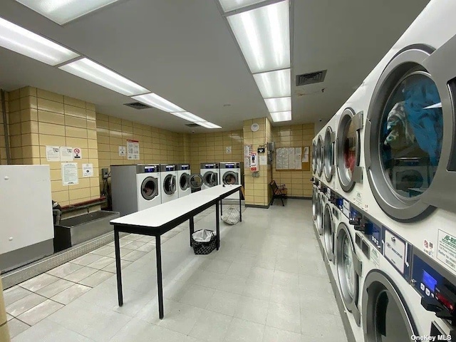 clothes washing area with washing machine and clothes dryer and stacked washer / dryer