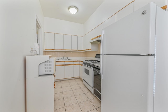 kitchen with light tile patterned floors, white cabinets, white appliances, and sink