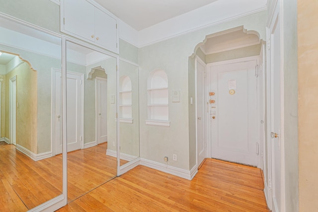 corridor featuring built in shelves and light hardwood / wood-style flooring