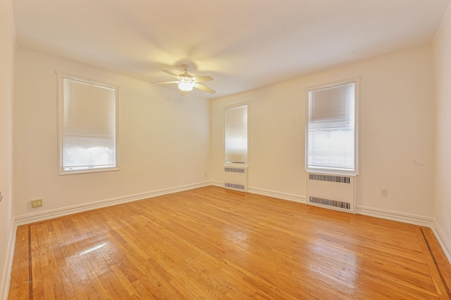 unfurnished room with radiator, ceiling fan, and light hardwood / wood-style flooring