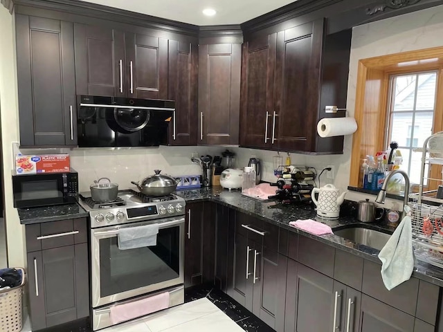 kitchen with dark brown cabinetry, sink, stainless steel gas range, dark stone counters, and light tile patterned floors