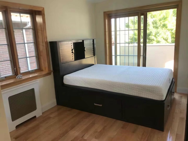 bedroom with light wood-type flooring and radiator