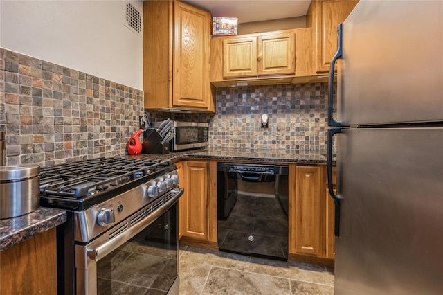 kitchen featuring backsplash, appliances with stainless steel finishes, and dark stone counters