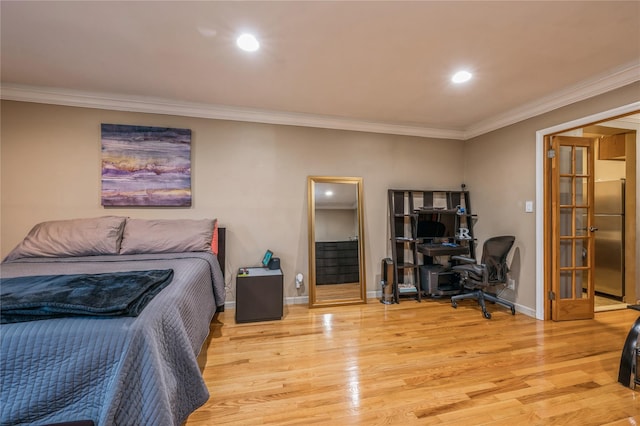 bedroom featuring stainless steel refrigerator, light hardwood / wood-style floors, and ornamental molding