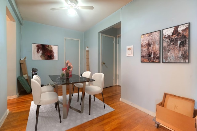 dining area with hardwood / wood-style flooring and ceiling fan