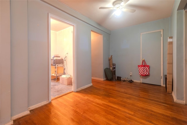 unfurnished bedroom with connected bathroom, hardwood / wood-style floors, and ceiling fan