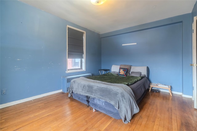 bedroom featuring hardwood / wood-style flooring and radiator heating unit